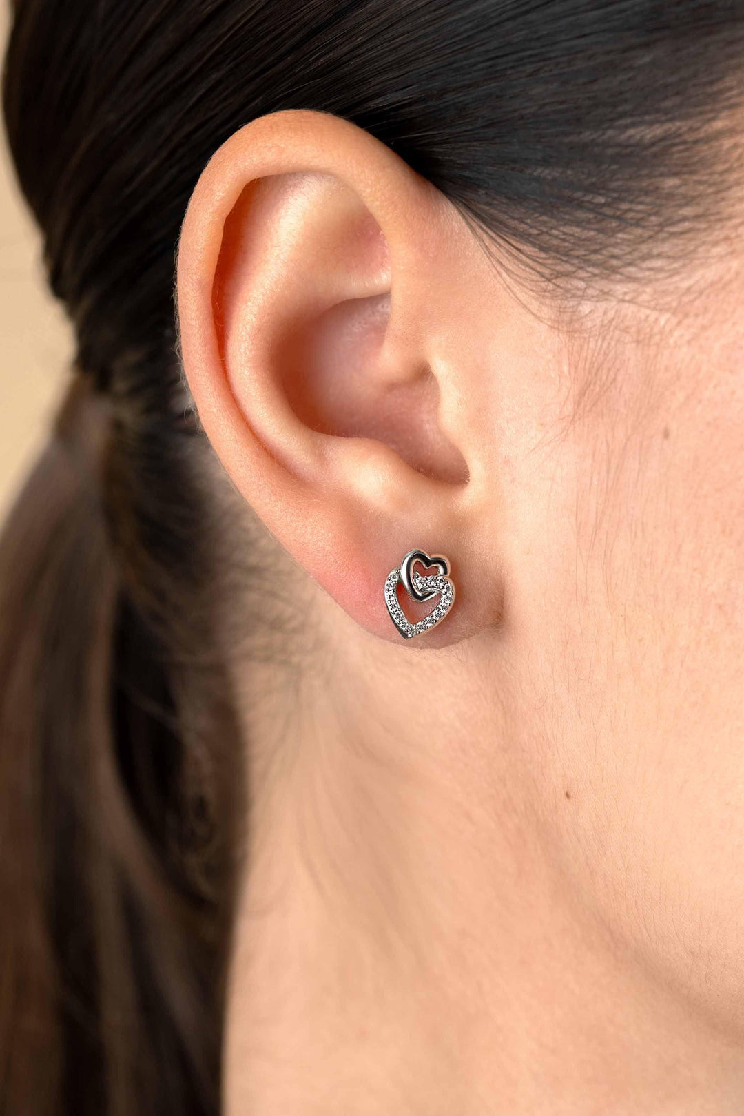 10mm ZINZI zilveren oorknoppen 2 open hartjes met elkaar verbonden, waarvan 1 hartje bezet met witte zirconia&