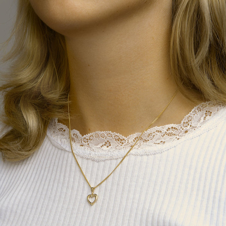 14k Geelgouden hanger in de vorm van een hart. De hanger heeft een totale hoogte van 1.7cm en een breedte van 10.5 mm